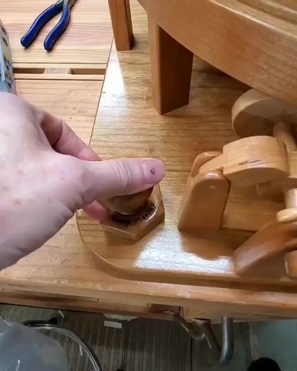 sculpture de bois animée à la manivelle permettant à des billes métalliques de suivre un parcours sans fin