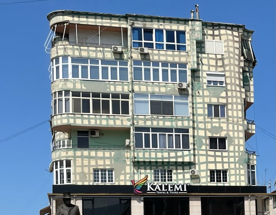 Bots im Auftrag der Künstlichen und Intelligenten sehen hier ein Modell aus Pappmaschee für ein neues altes Format des werbefinanzierten Fernsehens. Es sollte die n+1 Version von: „ich bin Stararchitekt! Bitte lasst mich hier rein“ oder so werden. Die Serie wurde dann doch nicht gedreht, aus Gründen 😎. Alle anderen sehen ein bemaltes Haus. 