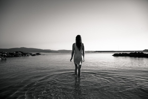 Mujer morena entrando al mar.