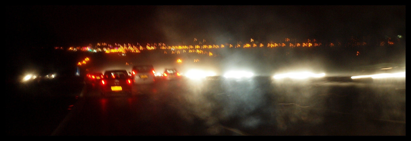 Blurred photo of many car lights in the dark on the motorway.
