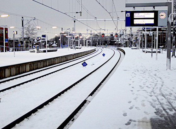 Foto van perrons en sporen onder een sneeuwlaag
