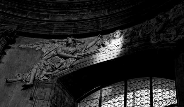 Black and white image of angels carved into the stone wall of a Gothic cathedral