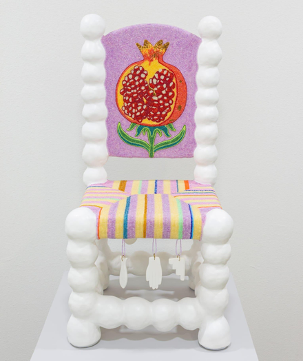 a white chair with a bulbous structure and beaded seat and back