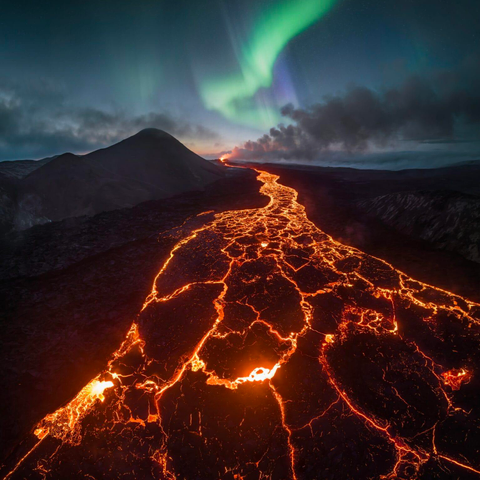 An aerial photograph by Max Terwindt of a volcanic eruptions and the aurora borealis in Iceland