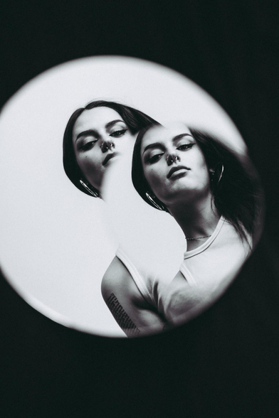 Mujer reflejada en dos espejos.