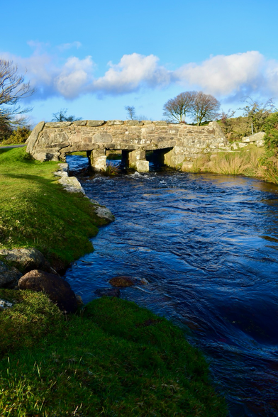 A stone bridge with a blue stream underneath.