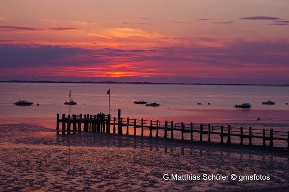 Kleine Boot vor Anker am abendlichen Strand vor Föhr im Sonneununtergang