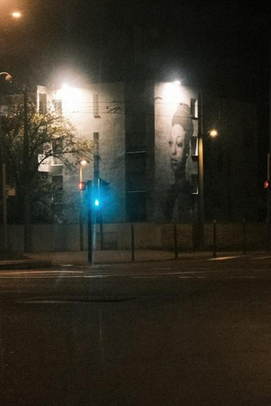 Portrait dessiné de Joséphine Baker sur la façade d'un immeuble, prise de nuit.