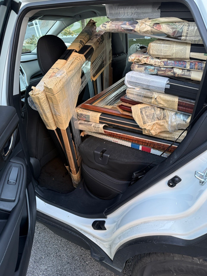 A view from a back passenger door of an SUV filled with frames.