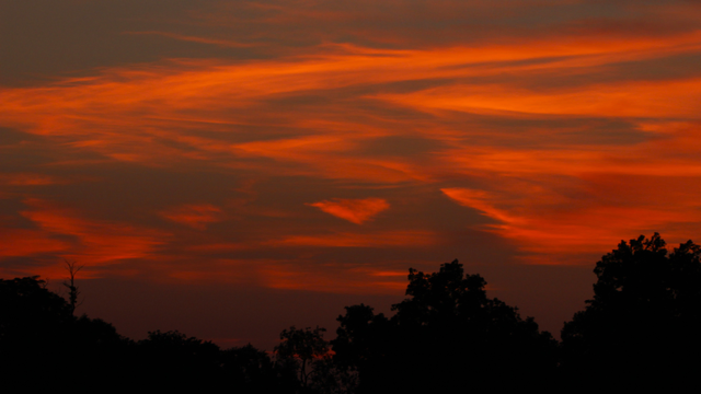 Sunset photograph of red clouds in the sky with a heart-shaped cloud in the middle.