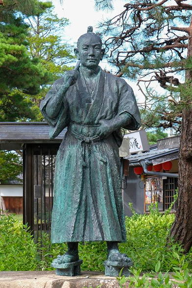 Bronze greening statue of young samurai in traditional clothes near Takayama Jinya and site of Jinya-mae Morning Market, Gifu prefecture, Japan, Asia.