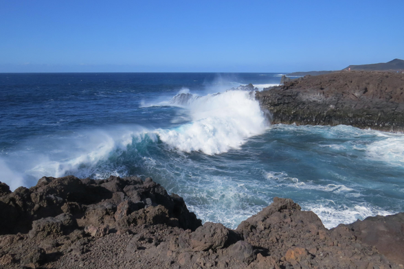 Eine große Welle bricht sich an den vulkanischen Felsen auf Lanzarote 
