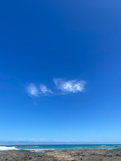 Blue sky with small tufts of cloud in the centre.