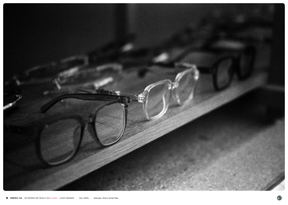 안경 가게의 진열장에 투명한 뿔테 디자인의 안경이 나열되어 있는 모습.