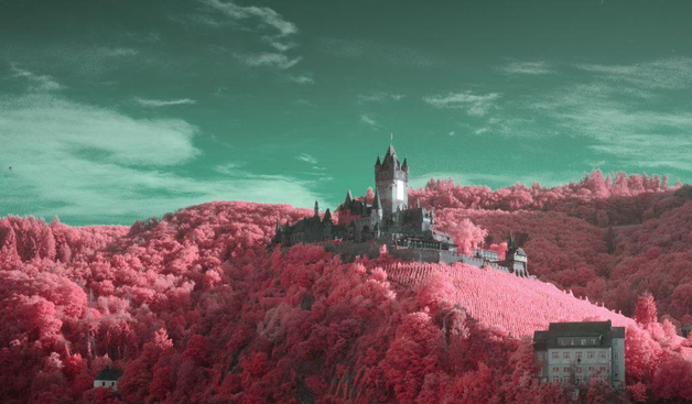 Similar view in bright weather, the evening sun reflecting in a large metallic mosaic on the front of the main towet. Very Lord of the Rings meets Alice in Wonderland