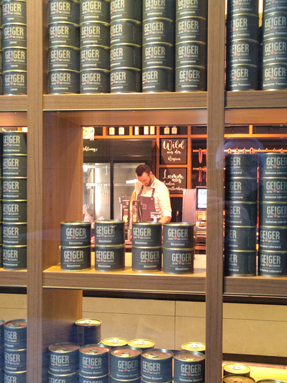 Blick durch ein Schaufensterregal auf einen Mitarbeiter