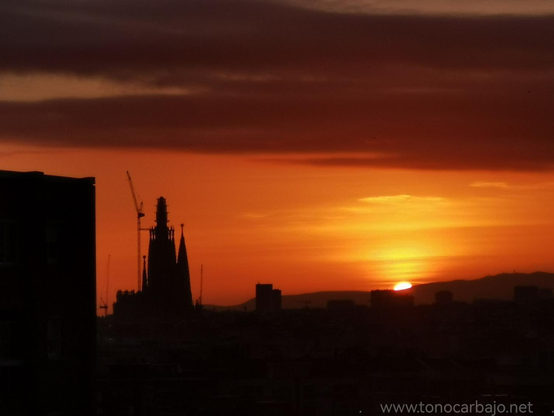 Ultimos rayos de sol del día. El cielo completamente naranja con la Sagrada Familia a contraluz a las izquierda