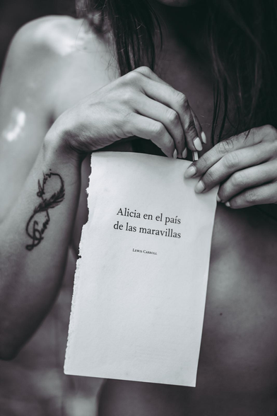 Chica con hoja del libro Alicia en el país de las maravillas.