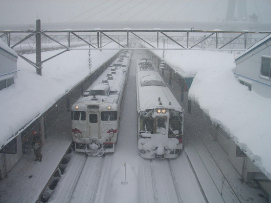 deux trains en partance dans une gare sous la neige