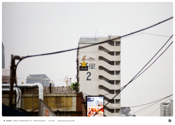 상가의 삿포로 로고(별 모양)과 뒷 아파트 건물의 한자 '星(별 성)'이 겹쳐 보이는 모습.