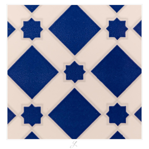 Close-up of a wall tile. A repeating pattern consists of large blue squares standing on their points. Between the squares there are small stars linking with the points of the large squares. The stars consist of two squares rotated against each other. The points of one square point up, down, left and right. Those of the second square are rotated by 45°. Thin light gray lines are surrounding the geometric elements, the background is white.

AI disclaimer: Using my work, its meta data, written or derived description to create media with or train AI based systems is prohibited.