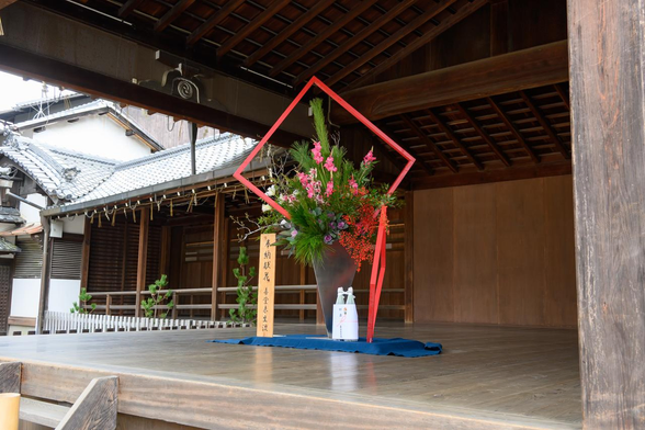 能舞台の中央に奉納された献花と酒が飾られている。/ 2026.01.04 八坂神社から