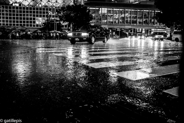 Taxi travessant la famosa cruïlla de Shibuya un dia de molta pluja.