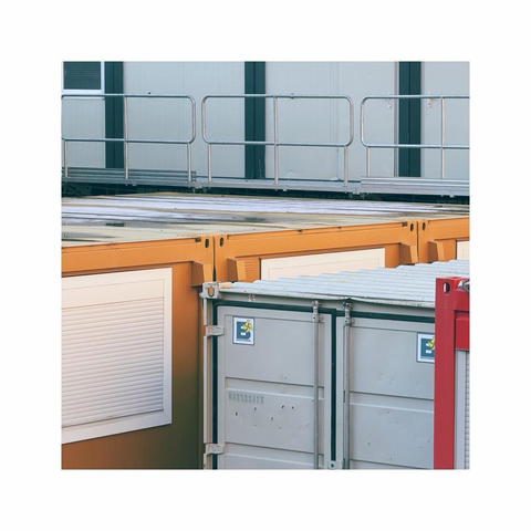 a square image showing some stacked shipping containers on a construction site. the containers come with different colors, details and logos. the crop is very focused and narrow