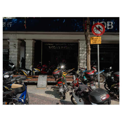 Motorcycles parked by the sidewalk despite the sign that says no parking on the sidewalk. Location Kuala Lumpur, Malaysia. 