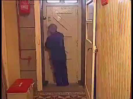 un gardien de phare verrouillant sa porte à triple tour et disposant des épars pour la barricader contre la mer