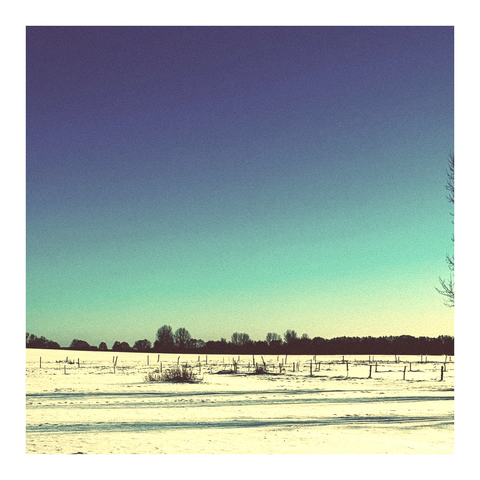 Am Himmel ein Übergang von Blau nach Türkis und gelblich schimmernde Wiesen-Schneelandschaft