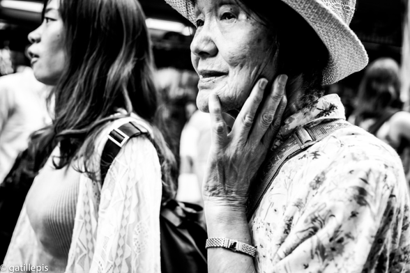 Primer pla d'una àvia amb barret, tocant-se la cara.