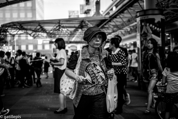 Senyora gran protegida del sol de l'estiu amb un barret amb visera i de la calor amb un pai-pai (ventall)