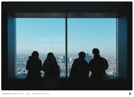 도쿄 도청 전망대에서 4 명의 사람이 넓은 창문 앞에서 도시를 바라보고 있는 모습.