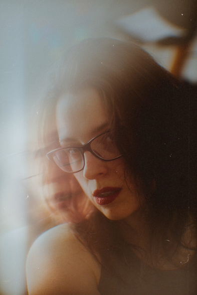 Heavily edited portrait of a woman with motion blur effect and film grain overlay.