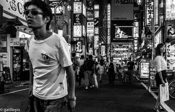 Primer pla d'home jove caminant amb ulleres de sol als carrers de Kabukicho, Tòquio