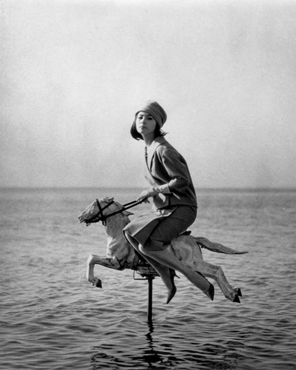 une femme adulte chevauchant en amazone un cheval de manège en pleine mer