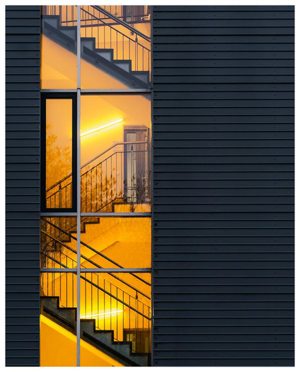 Großes Gebäude mit Blick aufs Treppenhaus durch ein Fenster. 