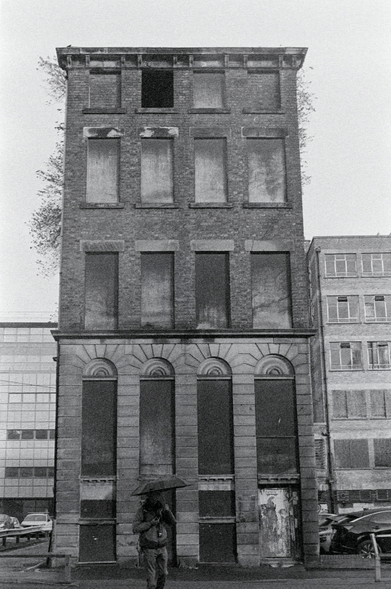 A Black and White 35mm film photograph of a derelict 5 storey building in Liverpool city center. The photo was taken on a grey overcast day whilst I was on a photowalk with friends in late November 2025.