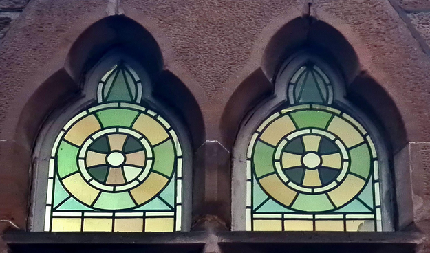 Stained glasa windows made up of geometric shapes made out of different coloured pieces of glass.