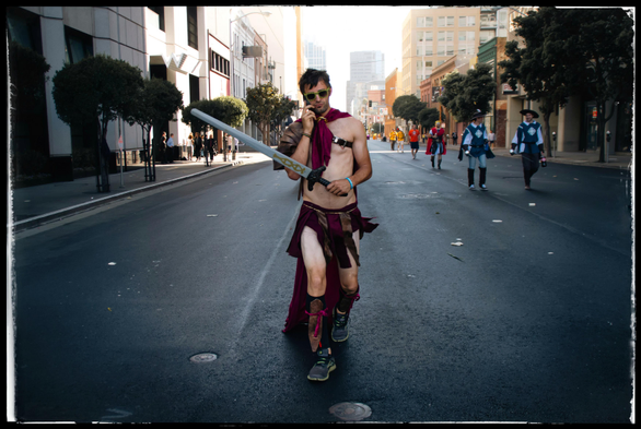 A photo taken in 2012 in downtown San Francisco, during the annual Bay to Breakers race... A glorious, barely serious, frequently unsober footrace from one end of San Francisco to the other. 

Here a runner wearing a magenta cape and kilt and not much else strides up Howard Street, South of Market while talking on his phone. The fantasy cosplayer is carrying a nordic-looking sword and appears to be ready to conquer a country or smite an enemy of democracy in the White House. Yes, please.