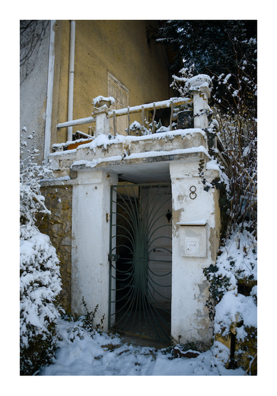Daylight photography

The mysterious snowy entrance of the number eight, with grid, old stone pillars and unhinged greenery.