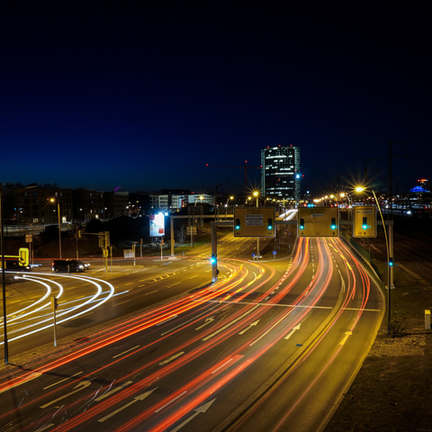 Lichtlinien von fahrenden Autos auf einer Kreuzung in Mannheim, im Hintergrund der erleuchtete Viktoriaturm