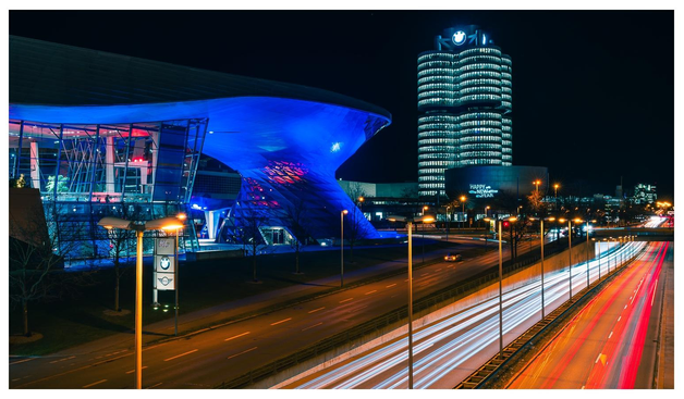 Lichtspuren fahrender Autos auf Großstadthighway vor dem Firmensitz eines mittelständischen bayrischen Automobilbauers.
