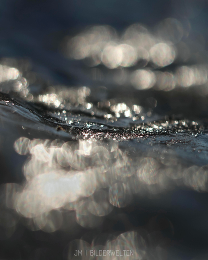A close-up image of shimmering icy surface with soft bokeh effects, showcasing light reflections and a sense of fluid movement. The colors are muted, emphasizing the texture and light interplay.

Ein Nahaufnahmebild einer schimmernden eisigen Oberfläche mit weichen Bokeh-Effekten, die Lichtreflexionen und ein Gefühl von Flüssigkeitsbewegung zeigen. Die Farben sind gedämpft, was die Textur und das leichte Zusammenspiel betont.