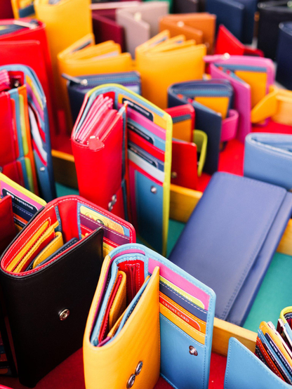 Closeup view of colorful wallets at a street market stand.