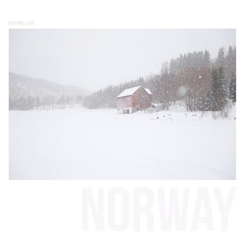 Red farm shed speckled white by snow flakes.