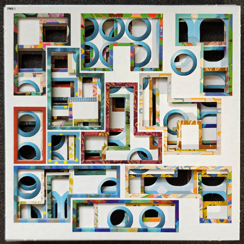 A photo of  several layered white cardboard squares with rectangular and circular cutouts.