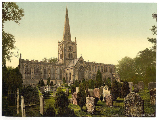 The image depicts an old, grand church with a prominent spire and clock tower. The architecture suggests Gothic style, characterized by pointed arches, large windows, and intricate stone carvings visible on the façade of the building. Surrounding the church is a well-maintained graveyard adorned with numerous headstones in various shapes and sizes, indicating it's an established resting place for many years. Trees border the scene, adding to the tranquil ambiance typical of such historic sites.

The photograph appears vintage, potentially dating from around 1890-1900, as indicated by its coloration and overall quality. This suggests that Trinity Church Yard in Stratford-on-Avon was captured during a time when churchyard burials were common practice before modern cemetery designs became prevalent.

Stratford-upon-Avon is known for being the birthplace of William Shakespeare, adding cultural significance to this location. The image serves as a historical snapshot, reflecting both architectural heritage and community life in Britain's past centuries.