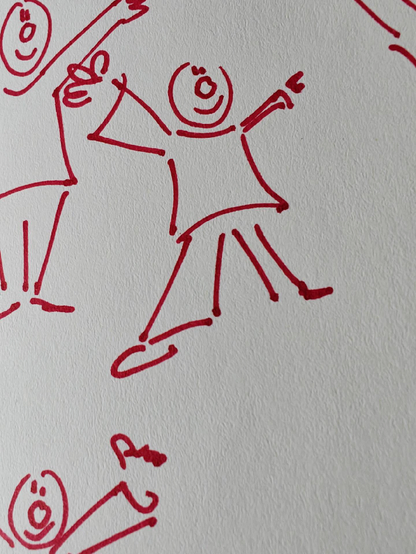 A photo of a red-pen doodle of simplified human figures, smiling and with raised arms.
